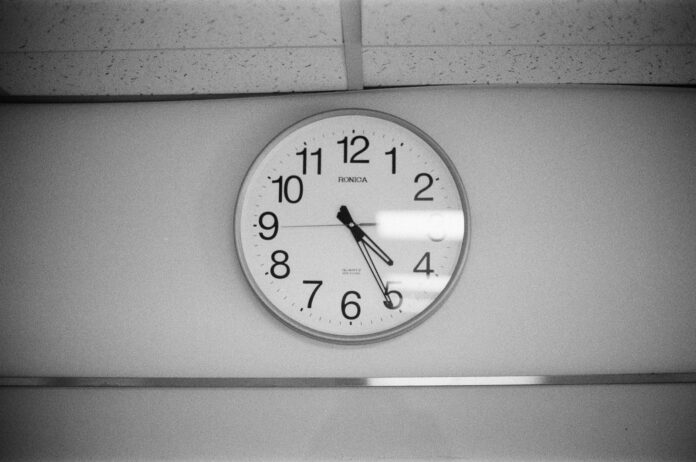 A black and white photo of a clock on a wall